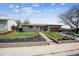 Charming single-story home featuring a well-manicured lawn and a stone pathway leading to the front door at 9508 Lou Dr, Northglenn, CO 80260