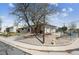Charming home exterior featuring a large tree, a yard, and a driveway at 9508 Lou Dr, Northglenn, CO 80260