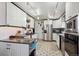 Well-lit kitchen featuring ample white cabinetry, granite countertops, modern appliances, and stylish tile flooring at 9508 Lou Dr, Northglenn, CO 80260