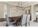 Inviting dining area with a view of the kitchen, featuring a sleek chandelier and ample seating at 22665 E Calhoun Pl, Aurora, CO 80016