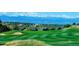 Rolling hills of a well-maintained golf course with neighborhood homes and mountains in the background at 22665 E Calhoun Pl, Aurora, CO 80016