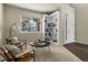 Bright room with a built-in bookshelf, comfortable chairs, and a pleasant view outside the large window at 22665 E Calhoun Pl, Aurora, CO 80016