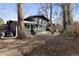 Backyard with trees and play structure behind a black home with a fenced in backyard at 1345 S Ivy Way, Denver, CO 80224