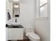Stylish half bathroom with vessel sink, dark countertop, and modern fixtures at 1345 S Ivy Way, Denver, CO 80224