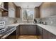 Well-lit kitchen showcases wood cabinets, geometric backsplash, stainless appliances, ample counter space, and hardwood floors at 1345 S Ivy Way, Denver, CO 80224