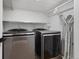 Convenient laundry room features modern washer and dryer, plus shelving and hanging space at 1345 S Ivy Way, Denver, CO 80224