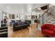 Open-concept living room featuring hardwood floors, modern staircase, and a dining area with large windows at 1345 S Ivy Way, Denver, CO 80224