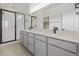 Modern bathroom featuring a dual sink vanity, black fixtures, and a glass enclosed shower at 20530 E 58Th Ave, Aurora, CO 80019