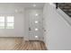 Bright entryway with modern door with square windows, wood floors, and staircase at 20530 E 58Th Ave, Aurora, CO 80019