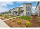 View of the exteriors of multiple gray townhomes with sidewalks and grass lawns at 20530 E 58Th Ave, Aurora, CO 80019