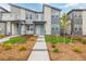 Beautiful townhome with modern exterior, stone accents, a landscaped yard, and concrete walkway at 20530 E 58Th Ave, Aurora, CO 80019