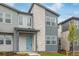 Close-up of a townhome's exterior with a light blue door and stone accents at 20530 E 58Th Ave, Aurora, CO 80019