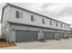 Exterior of modern townhomes showcasing attached garages and coordinated design at 20530 E 58Th Ave, Aurora, CO 80019