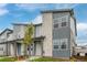 Townhome exterior featuring gray siding, stone accents, and a landscaped yard at 20530 E 58Th Ave, Aurora, CO 80019