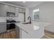 Bright kitchen featuring gray cabinets, stainless steel appliances, and a large center island with sink at 20530 E 58Th Ave, Aurora, CO 80019