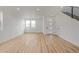 Large living room with expansive wood floors, minimalist staircase, and modern white walls at 20530 E 58Th Ave, Aurora, CO 80019