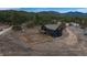 Aerial view of a black two-story home with fenced yard surrounded by trees at 28364 Tresine Dr, Evergreen, CO 80439