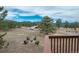 Scenic backyard view from the deck with a firepit surrounded by chairs and mountain views at 28364 Tresine Dr, Evergreen, CO 80439