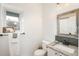 Well-lit bathroom with granite countertop, wooden mirror frame, and a window above the toilet at 28364 Tresine Dr, Evergreen, CO 80439
