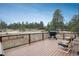 Deck with black grill and outdoor furniture overlooking a wooded area at 28364 Tresine Dr, Evergreen, CO 80439