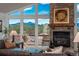 Comfortable living room featuring a stone fireplace, plush seating, and stunning views of the surrounding landscape at 28364 Tresine Dr, Evergreen, CO 80439