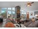 Bright living room with a stone fireplace, large windows, and an oversized comfortable couch at 28364 Tresine Dr, Evergreen, CO 80439