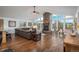 Open-concept living area with a fireplace, large windows, and hardwood floors at 28364 Tresine Dr, Evergreen, CO 80439