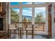 Cozy living area with a stone fireplace and picturesque mountain views through large windows at 28364 Tresine Dr, Evergreen, CO 80439