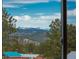 Beautiful mountain view framed by trees, seen from inside the home at 28364 Tresine Dr, Evergreen, CO 80439