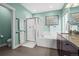 Bright bathroom featuring a glass-enclosed shower, soaking tub, and double vanity at 11346 E 27Th Ave, Denver, CO 80238