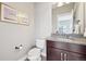Stylish powder room with granite countertop, modern fixtures, and decorative artwork at 11346 E 27Th Ave, Denver, CO 80238