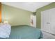 A tranquil bedroom featuring soft, green walls and access to the staircase at 11346 E 27Th Ave, Denver, CO 80238