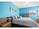 Bright bedroom featuring blue walls, a cozy bed, and natural light from the window at 11346 E 27Th Ave, Denver, CO 80238
