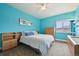 Bright bedroom with blue walls, natural light, and furniture including a bed, dresser and desk at 11346 E 27Th Ave, Denver, CO 80238