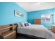 Bedroom with bright, blue walls, ample natural light, and wooden accents and furnishings at 11346 E 27Th Ave, Denver, CO 80238