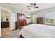 Spacious bedroom featuring a ceiling fan, television, and stylish wooden furniture and a connected bathroom at 11346 E 27Th Ave, Denver, CO 80238