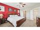 Cozy bedroom with a striking red accent wall, featuring a comfortable bed and elegant artwork at 11346 E 27Th Ave, Denver, CO 80238