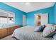 Bright bedroom features blue walls, a large window, and a comfortable bed with decorative pillows at 11346 E 27Th Ave, Denver, CO 80238