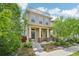Inviting two-story home with a charming front porch and rooftop balcony, surrounded by lush greenery at 11346 E 27Th Ave, Denver, CO 80238