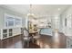 Inviting eat in kitchen featuring white cabinets, hardwood floors, stainless appliances, and stylish pendant lighting at 11346 E 27Th Ave, Denver, CO 80238