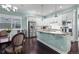 Bright kitchen with white cabinets, stainless steel refrigerator, and a view of the dining area at 11346 E 27Th Ave, Denver, CO 80238
