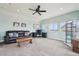 Comfortable living room with a ceiling fan, brown leather sofa, desk area and bright windows at 11346 E 27Th Ave, Denver, CO 80238