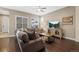 Cozy living room featuring a large sectional sofa, TV, and hardwood floors at 11346 E 27Th Ave, Denver, CO 80238