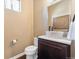 Elegant powder room with vessel sink, stone countertop, and decorative mirror at 1950 W 67Th Ave, Denver, CO 80221