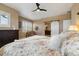 Cozy bedroom with floral bedding, ceiling fan and a sliding barn door to ensuite bathroom at 1950 W 67Th Ave, Denver, CO 80221