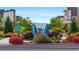 The community entrance is adorned with vibrant flowers, green landscaping, and modern architecture at 1950 W 67Th Ave, Denver, CO 80221