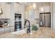 Close-up of kitchen island with granite countertops, a farmhouse sink, and stainless steel appliances at 1950 W 67Th Ave, Denver, CO 80221