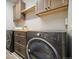 Modern laundry room features a front loading washer/dryer, cabinets and a countertop at 1950 W 67Th Ave, Denver, CO 80221