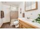 Bathroom features a glass-enclosed shower, wood vanity, and white tile walls at 11522 Pine Grove Ln, Parker, CO 80138