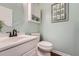 Modern half-bathroom featuring a decorative mirror, white vanity, and elegant fixtures at 11522 Pine Grove Ln, Parker, CO 80138